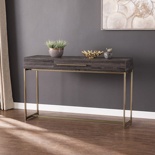 Dark gray wood console table with a drawer on a slim brushed gold base