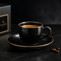 Black ceramic espresso cup and saucer with bronze rim